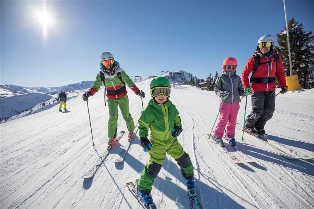 Kinder und Erwachsene beim Ski fahren